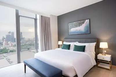 a bedroom with a large bed and a large window at Wyndham Bangkok Queen Convention Centre in Bangkok