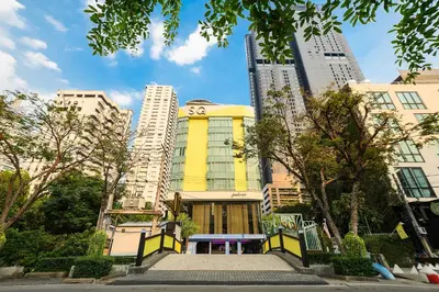 a yellow building in a city with tall buildings at SQ Boutique Hotel in Bangkok
