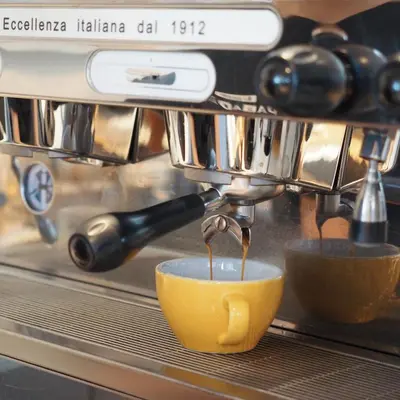 a coffee machine pouring coffee into a yellow cup at Shama Yen-Akat Bangkok in Bangkok