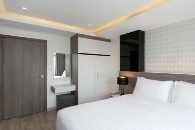 a bedroom with a large white bed and a mirror at ORION Hotel & Residence Bangna in Bangkok
