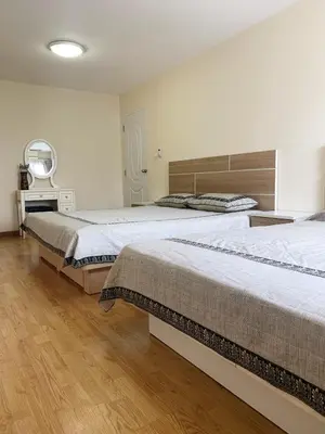 a bedroom with two beds and a desk at Charming Resident near BTS Ekkamai Station in Bangkok