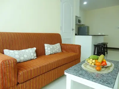 a living room with a couch and a bowl of fruit on a table at Charming Resident near BTS Ekkamai Station in Bangkok