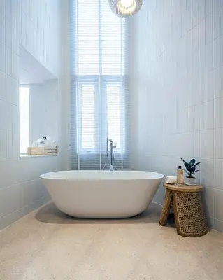 a white bath tub in a bathroom with a window at Bonsai Hotel Bangkok in Bangkok