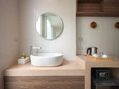 a bathroom with a tub and a mirror on a counter at Bonsai Hotel Bangkok in Bangkok
