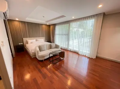 a bedroom with a bed and a chair and a window at ViVi Avenue Thonglor in Bangkok