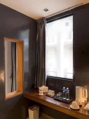 a room with a window and a table with water bottles at The Nhorm Hotel Ratchada in Bangkok