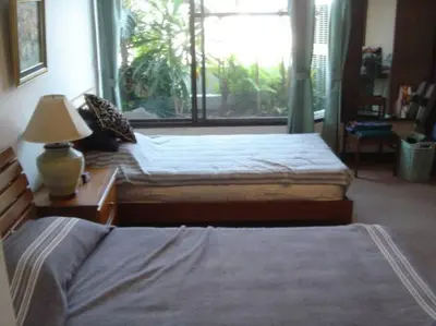 a bedroom with two beds and a large window at Stunning 24th Fl Terrace Penthouse! in Bangkok