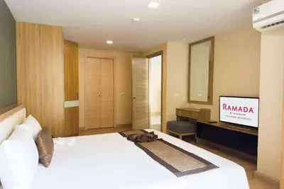 a hotel room with a bed and a television at Ramada Ekamai in Bangkok