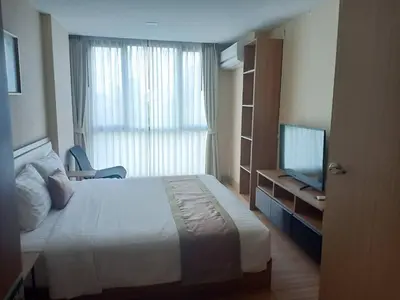 a hotel room with a bed and a television at Ramada Ekamai in Bangkok