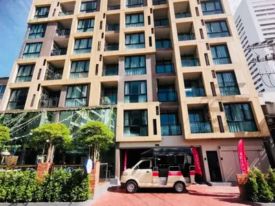 a small car parked in front of a tall building at Ramada Ekamai in Bangkok
