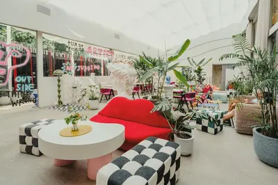 a room filled with lots of plants and a red couch at The Fig Lobby Bangkok in Bangkok