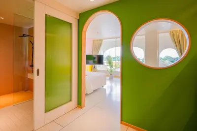 a bathroom with a green wall and a mirror at The Fig Lobby Bangkok in Bangkok