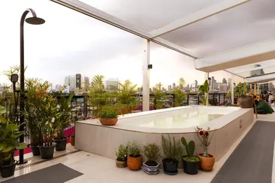 a hot tub on the roof of a building with plants at The Fig Lobby Bangkok in Bangkok