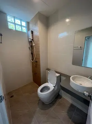 a bathroom with a toilet and a sink at Firstbuild Apartment (เฟิร์สบิวท์อพาร์ทเม้น) in Bangkok