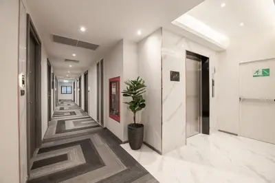 a hallway of an office building with a potted plant at Aspira Parc Sukhumvit 22 in Bangkok