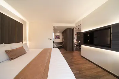 a hotel room with a large bed and a flat screen tv at Aspira Parc Sukhumvit 22 in Bangkok