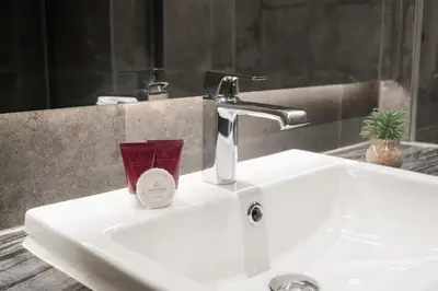 a bathroom sink with a faucet and a cup on it at Aspira Parc Sukhumvit 22 in Bangkok