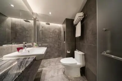 a bathroom with a white toilet and a sink at Aspira Parc Sukhumvit 22 in Bangkok