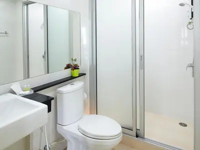 a bathroom with a toilet and a sink and a shower at The Plimplace Hotel in Bang Su
