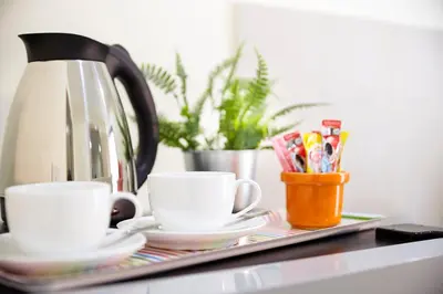 a tray with two coffee cups and a tea kettle at The Plimplace Hotel in Bang Su
