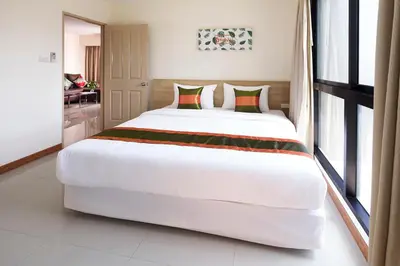 a large white bed in a room with windows at The Plimplace Hotel in Bang Su