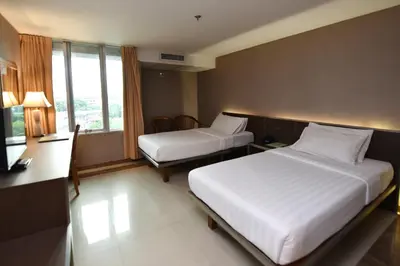 a hotel room with two beds and a window at Bangkok City Suite in Bangkok