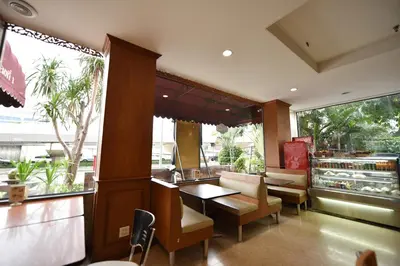 a restaurant with a table and chairs and a window at Bangkok City Suite in Bangkok