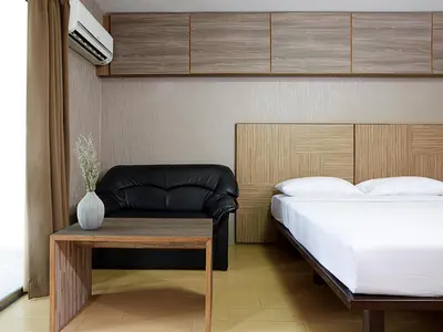 a bedroom with a bed and a table at Watana Hotel in Bangkok