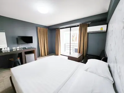 a bedroom with a large white bed and a window at Watana Hotel in Bangkok