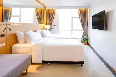 a hotel room with two beds and a television at FX HOTEL NANA in Bangkok