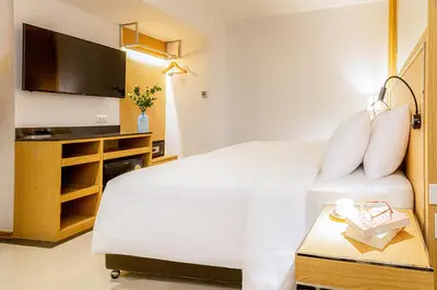 a hotel room with a bed and a flat screen tv at FX HOTEL NANA in Bangkok
