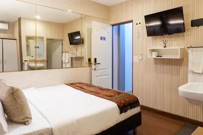 a bedroom with a bed and a sink and a mirror at Usman Halal Home in Bangkok