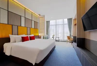 a hotel room with a large bed and a television at Ramada Plaza by Wyndham Bangkok Sukhumvit 48 in Bangkok