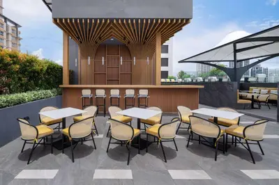 a restaurant with tables and chairs on a patio at Ramada Plaza by Wyndham Bangkok Sukhumvit 48 in Bangkok