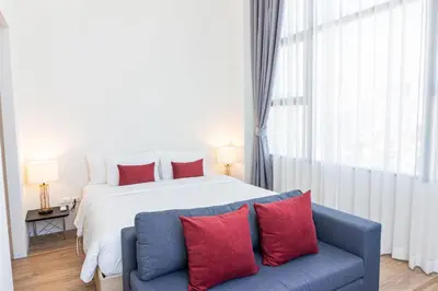 a bedroom with a large bed and a blue couch at Ramada Plaza by Wyndham Bangkok Sukhumvit 48 in Bangkok