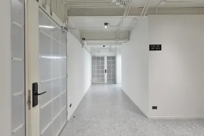 an empty corridor in an office building with white walls at Tiang Capsule in Bangkok