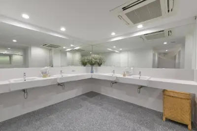 a bathroom with a row of sinks and mirrors at Tiang Capsule in Bangkok