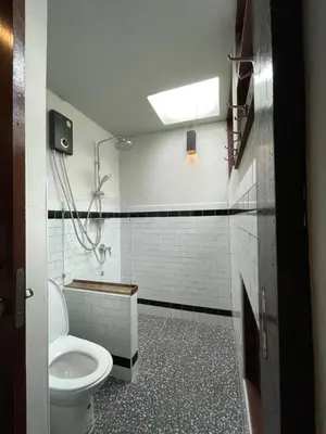 a bathroom with a toilet and a shower and a sink at Humz Canal Stay in Nonthaburi