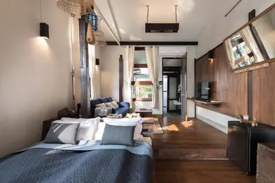 a bedroom with a bed and a living room at Humz Canal Stay in Nonthaburi