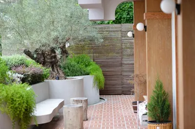 a garden with a white bench and trees and plants at VST Punnawithi in Bangkok
