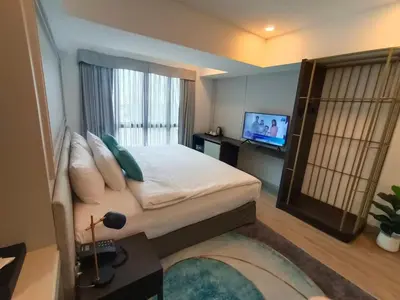 a bedroom with a large bed and a television at VIVA LA VIDA HOTEL in Bangkok