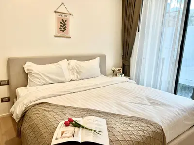 a bedroom with a bed with a book and flowers on it at Sukhumvit 11#Luxury#Pool#Gym#BTS Nana&MRT Sukhumvit#1BR#Max2ppl in Bangkok