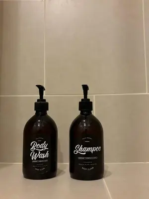 two bottles of laundry detergent sitting on a bathroom counter at Entire apartment near train station with pool & views in Ban Song Hong