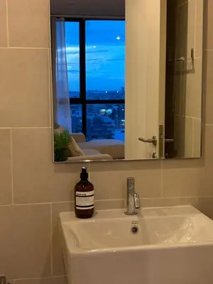 a bathroom sink with a bottle of soap on it at Entire apartment near train station with pool & views in Ban Song Hong