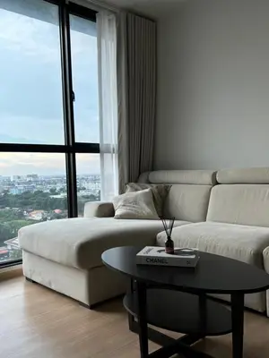 a living room with a white couch and a table at Entire apartment near train station with pool & views in Ban Song Hong