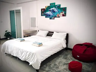 a bedroom with a white bed with a red bag on it at MY HOME Hotel - Phutthamonthon 4 Road, near Mahidol University Salaya in Ban Krathum Lom