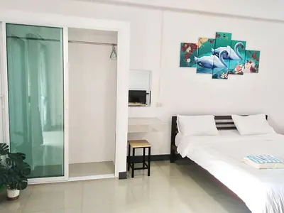 a white bedroom with a bed and a window at MY HOME Hotel - Phutthamonthon 4 Road, near Mahidol University Salaya in Ban Krathum Lom