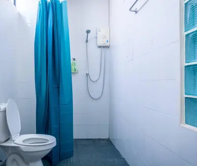 a bathroom with a blue shower curtain and a toilet at T4 Two Bedrooms Full kitchen/1 min to BTS in Bangkok