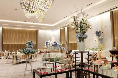 a banquet hall with tables and chairs and a chandelier at Asawin Grand Convention Hotel in Bangkok