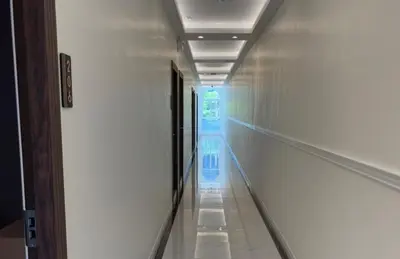 an empty aisle in a building with a hallway at Anwari Hotel in Bangkok